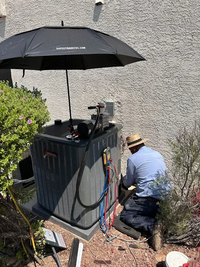 HVAC technician performing outdoor AC maintenance in Grand Rapids