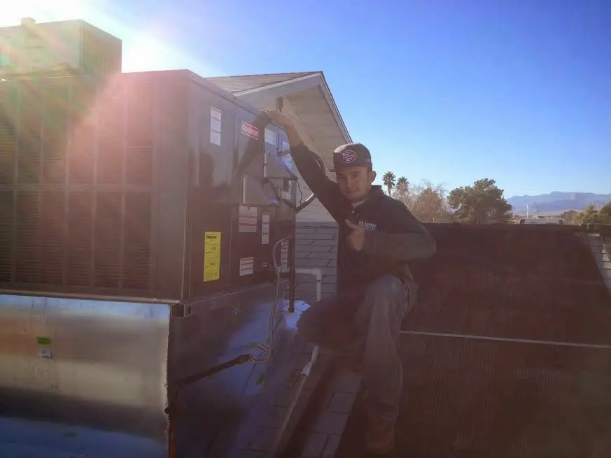 HVAC technician performing HVAC Inspection on a rooftop unit in Grand Rapids